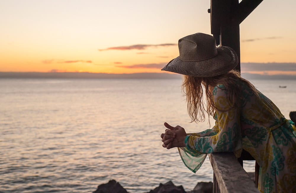 kobieta obserwująca zachód słońca nad oceanem
