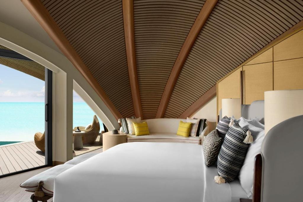 nujuma a ritz carlton reserve sypialnia w domku, sklepienie ścian w drewnie, jasne łóżko