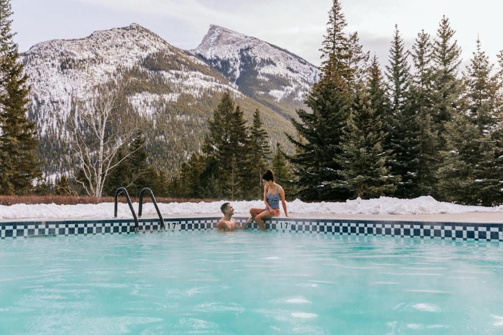 Открытый бассейн отеля Fairmont Banff Springs в горах зимой.
