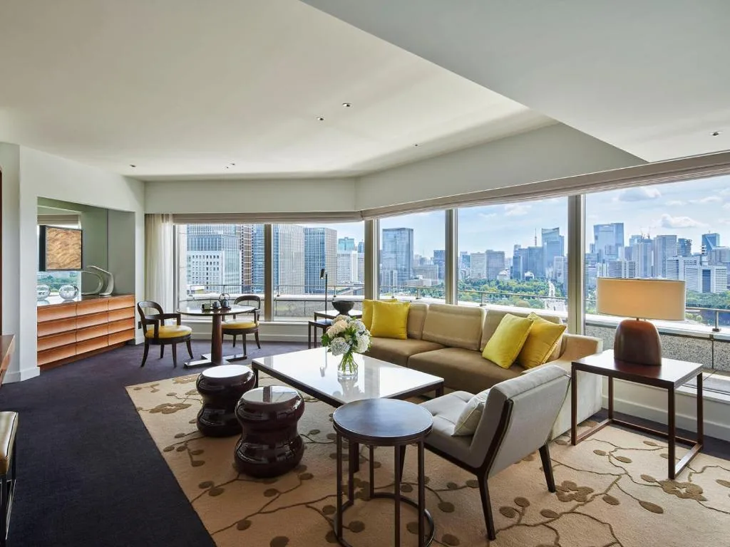Номер люкс в отеле Palace Hotel Tokyo - большой диван, стеклянные окна с видом на город.