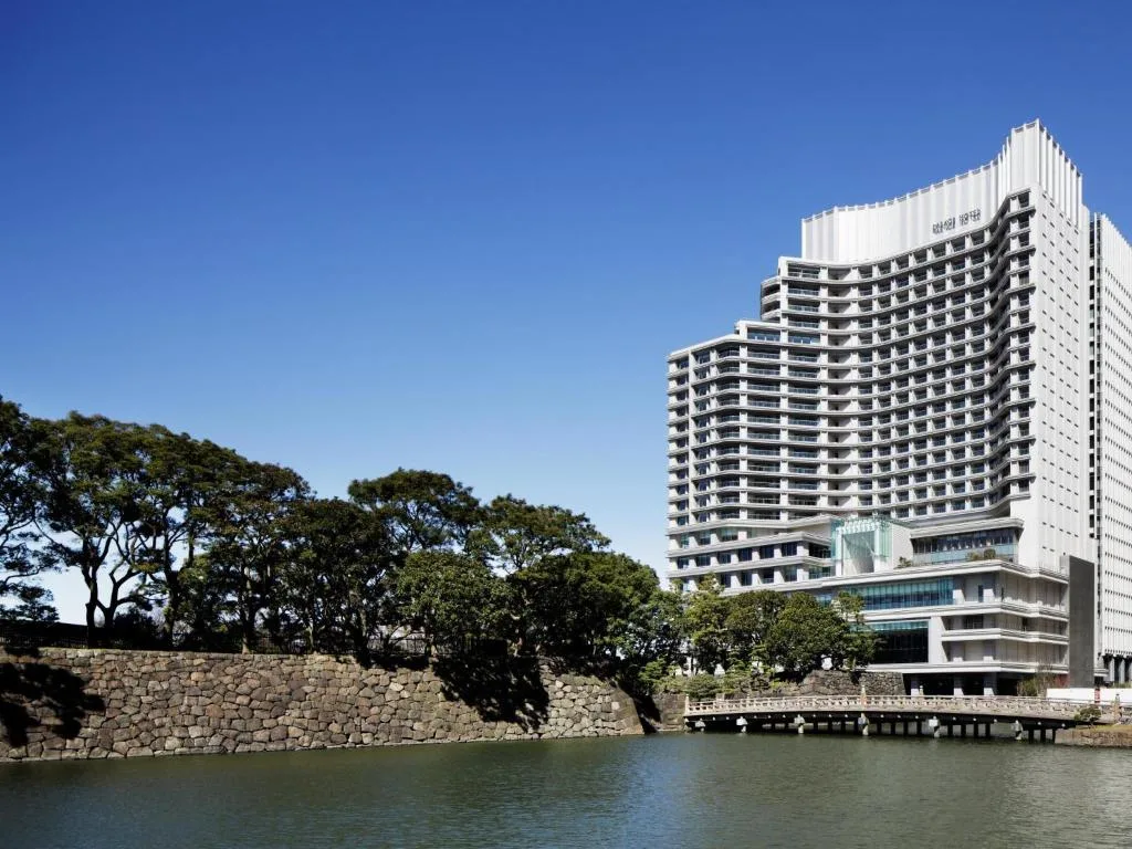Дневной вид на отель Palace Hotel Tokyo — в окружении воды и зелени.
