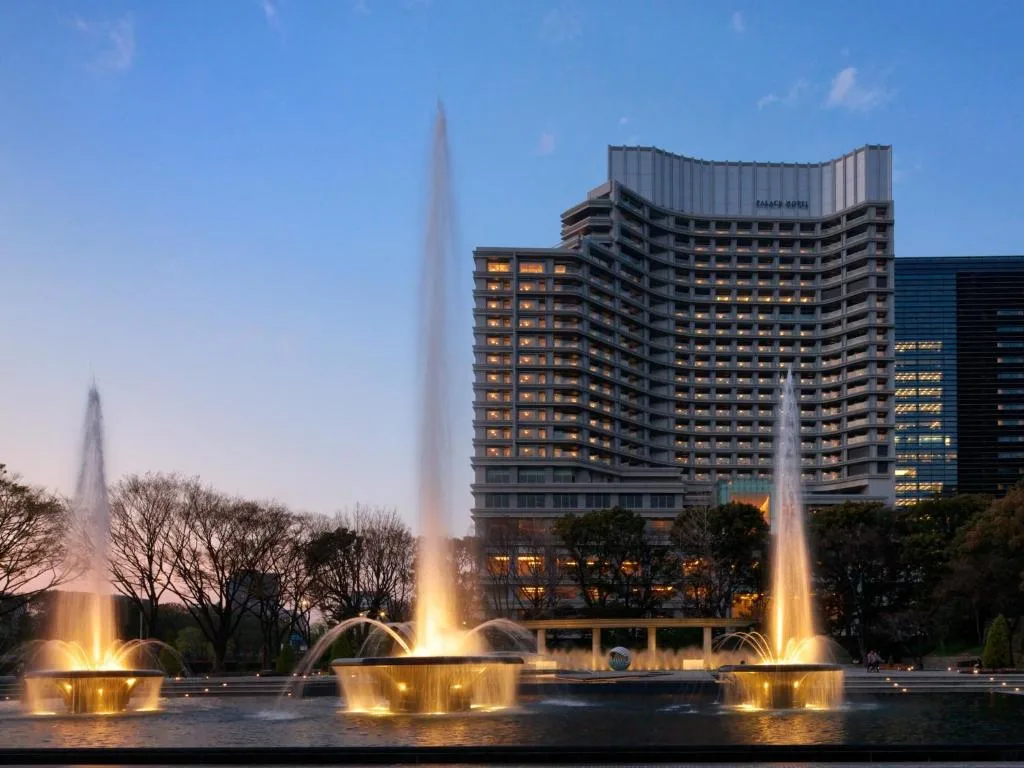 Вид на отель Palace Hotel Tokyo: здание в окружении подсвеченных фонтанов.